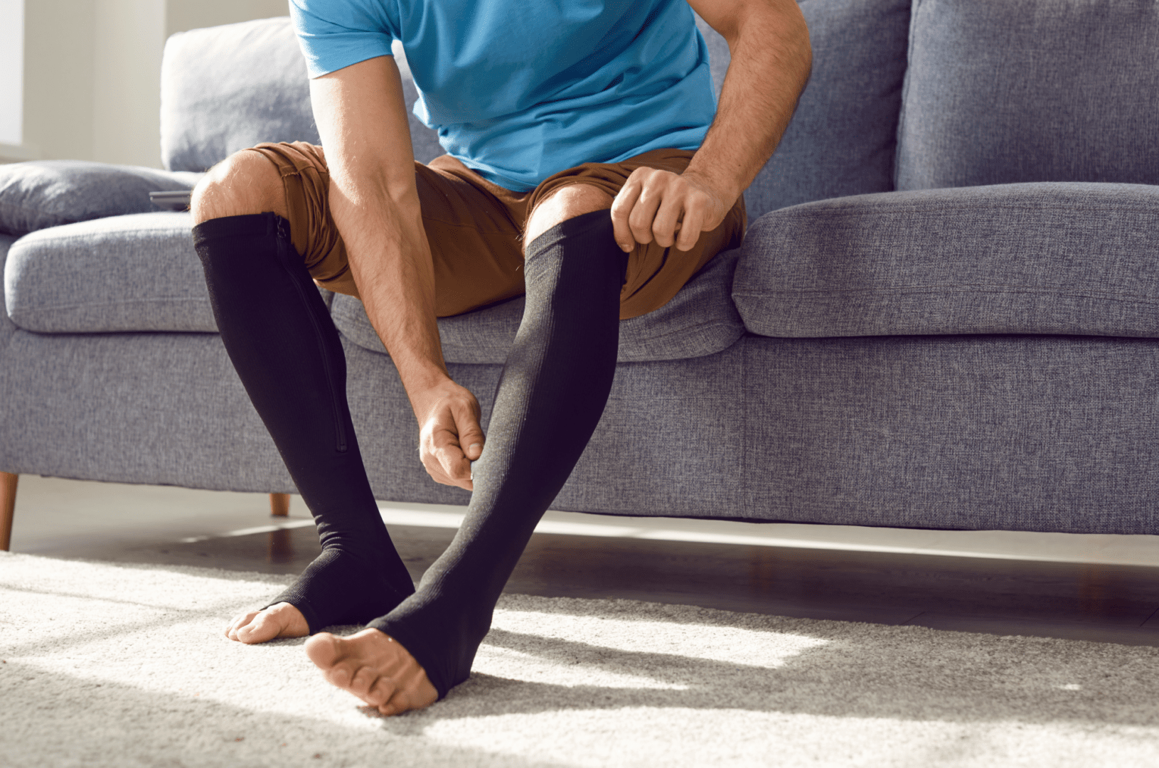 A man sitting on the floor with his legs crossed.