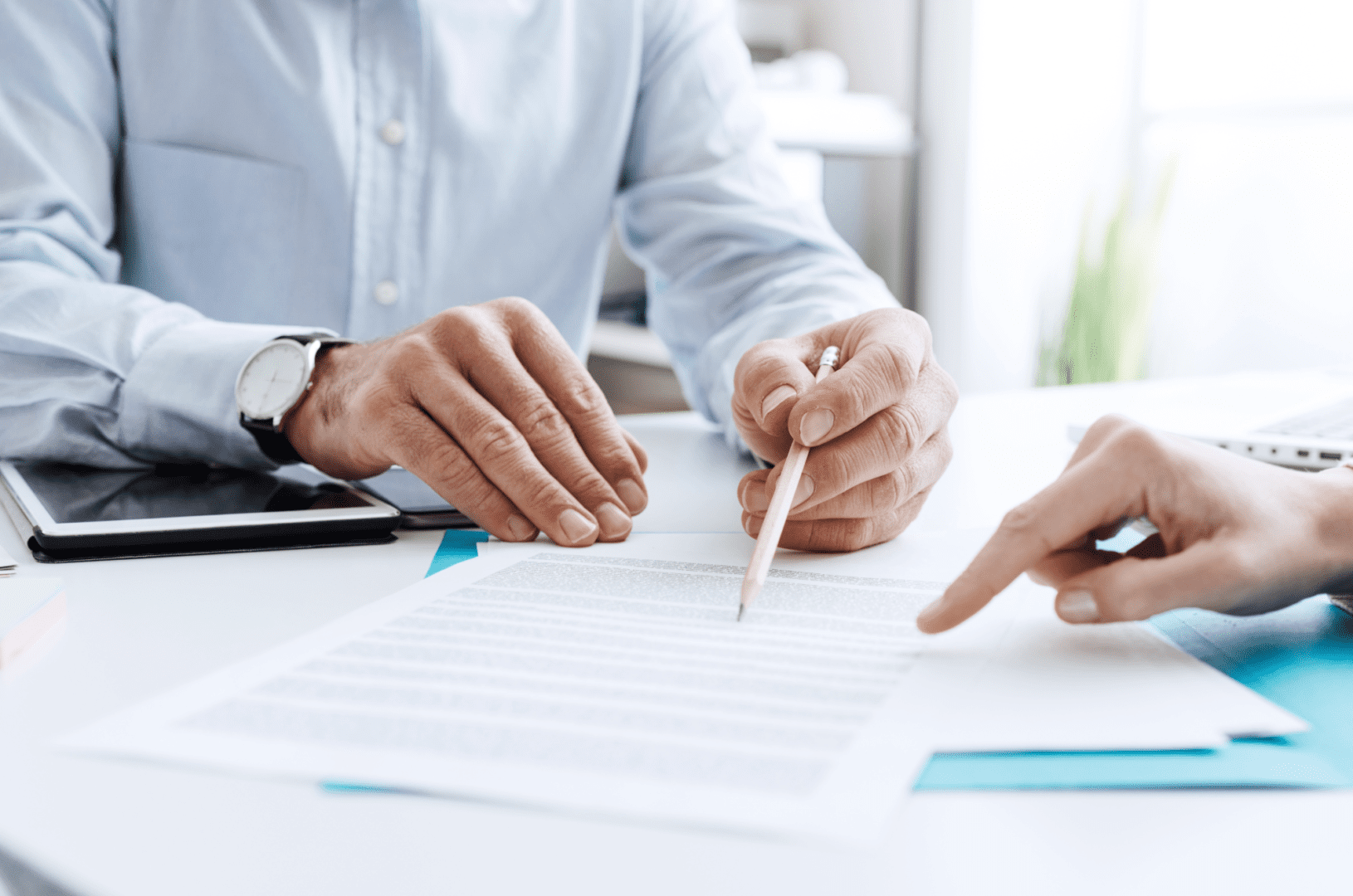 Two people are sitting at a table and one is holding a pencil