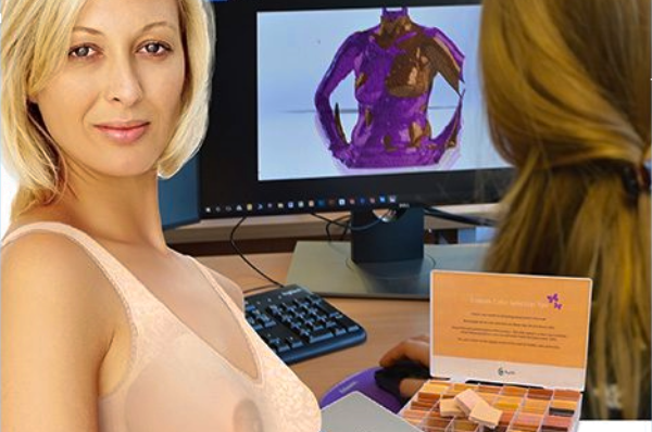 A woman sitting in front of a computer screen creating post-surgical and mastectomy bras.